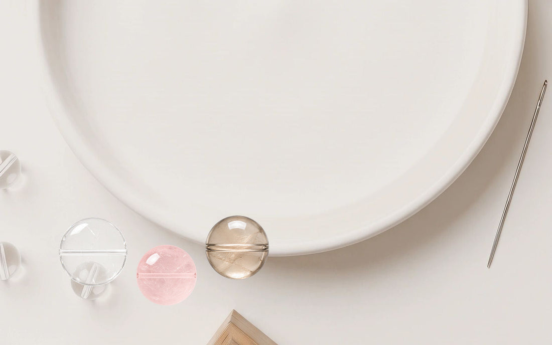 Natural crystal beads and bracelet-making tools on a soft ivory work surface