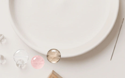 Natural crystal beads and bracelet-making tools on a soft ivory work surface